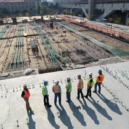 6 Personen stehen vor einem unfertigem Gebäude.